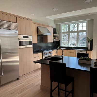 kitchen remodel in Lawrence, KS, at Kring's Interiors with wood cabinets, stone counters, and black tile backsplash