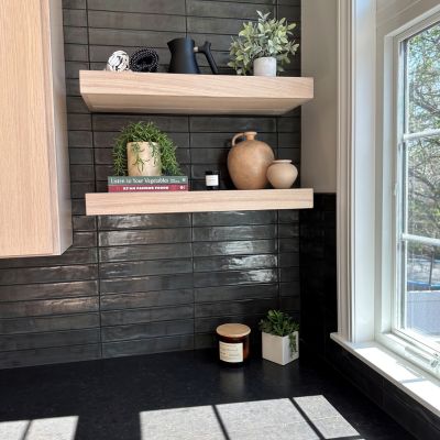black tile backsplash in a kitchen remodel with floating wood shelves