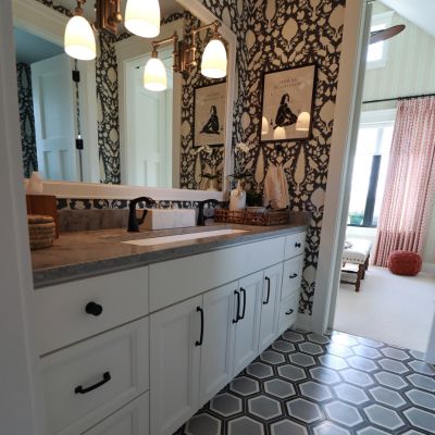 bath renovation with wallpaper and vanity lighting